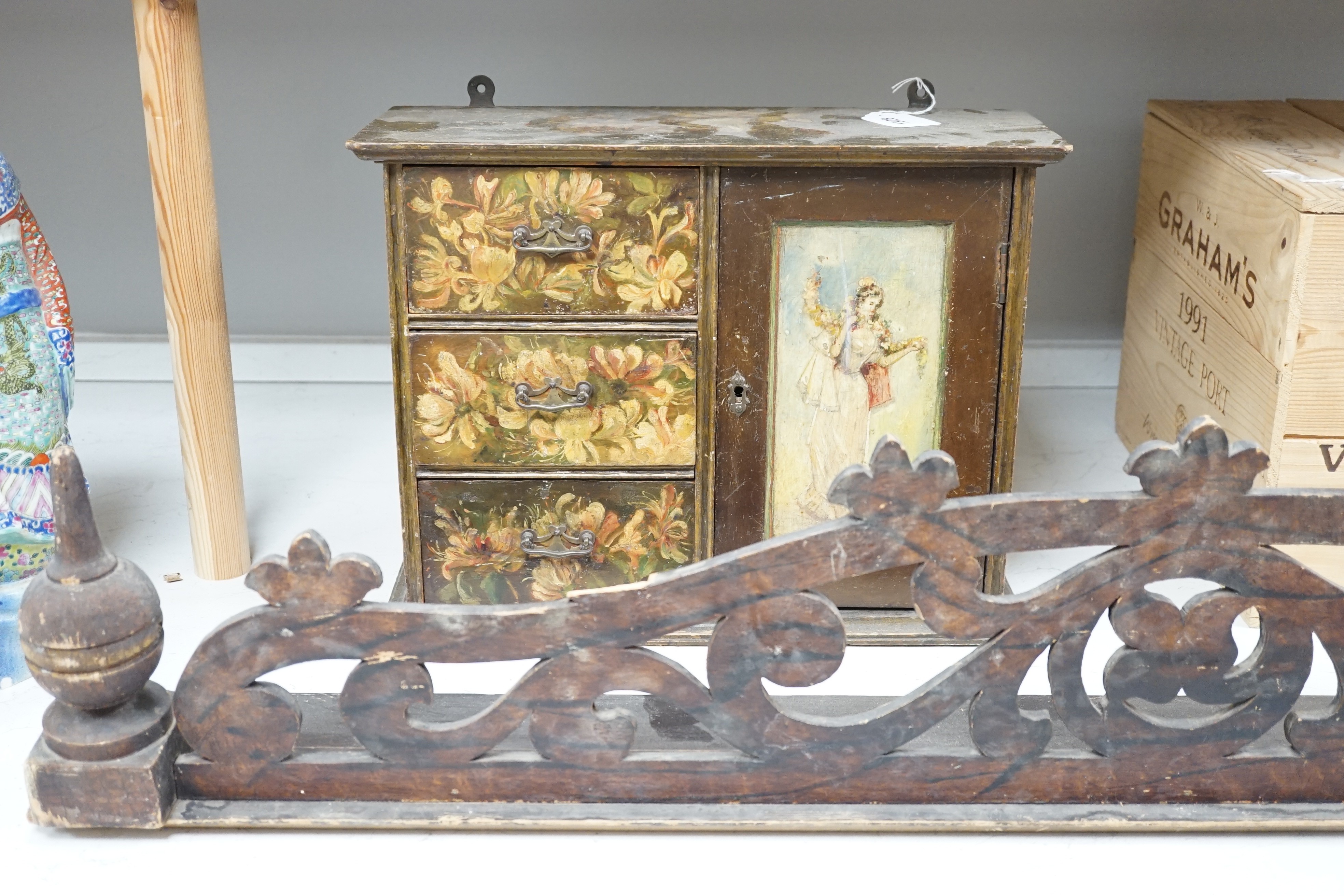 A painted wood hanging wall cupboard and a fret carved and grained wood pediment, 124cm